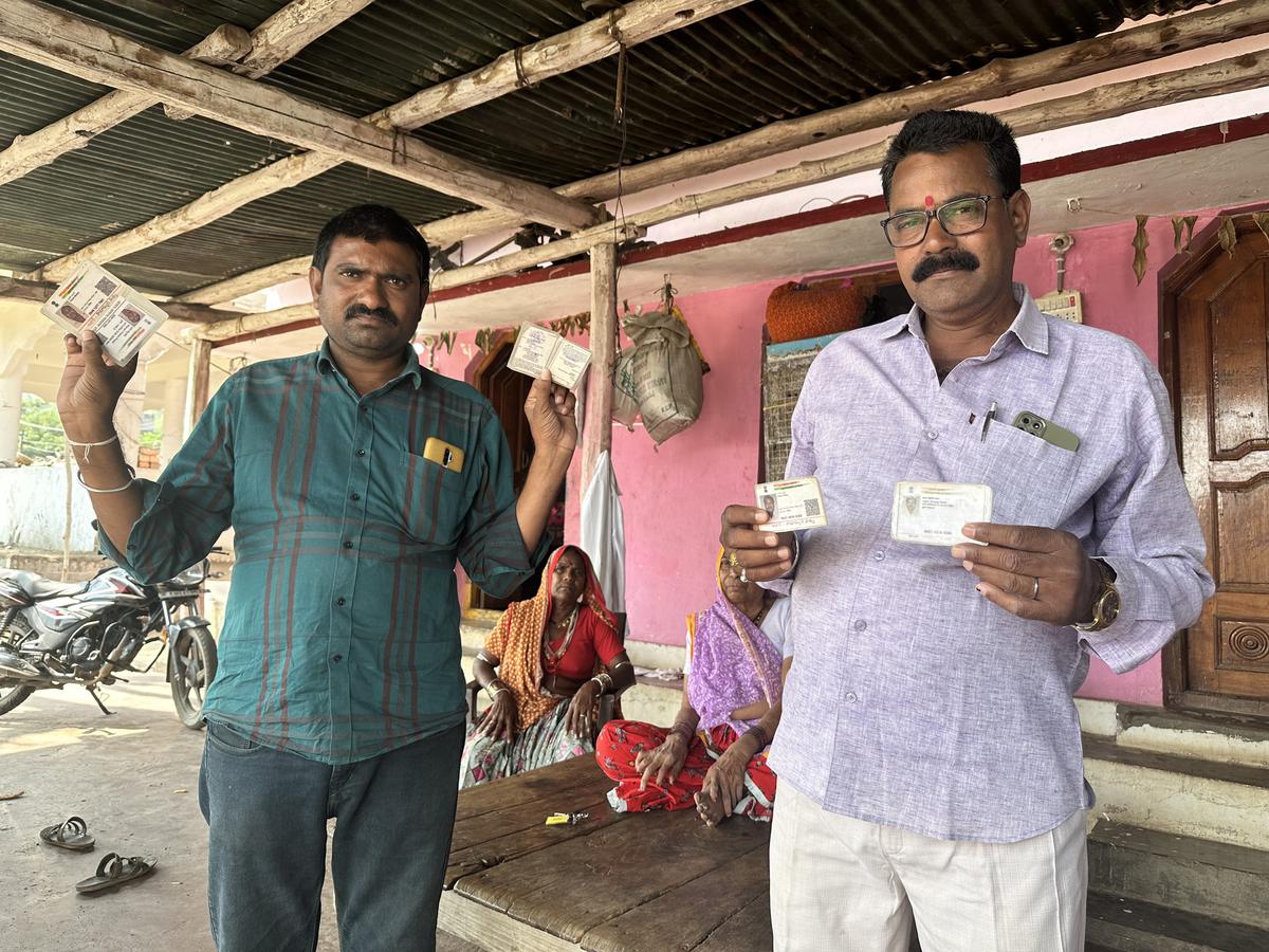 મહારાજગુડામાં ગ્રામજનો તેમના મતદાર ID અને આધાર કાર્ડ બતાવે છે. મહારાજગુડામાં ગ્રામજનો તેમના મતદાર ID અને આધાર કાર્ડ બતાવે છે.