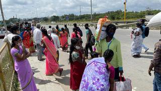 Travellers from Tamil Nadu get ready to cross the border on foot to board buses bound for Bengaluru, at Attibele on Hosur Road.