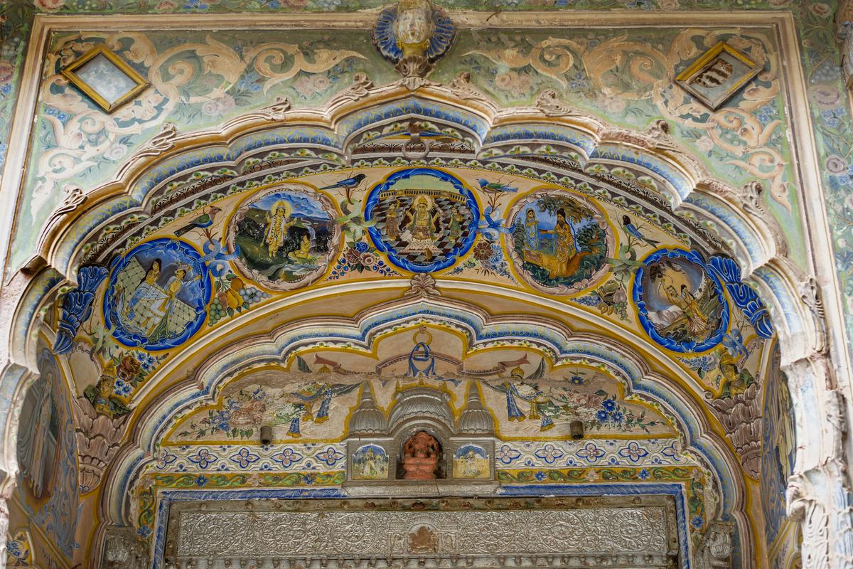 Murals depicting scenes of the Ramayana, Mahabharata, and more, above the courtyard door