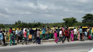 Travellers from Tamil Nadu cross the border on foot to board buses bound for Bengaluru, at Attibele on Hosur Road.