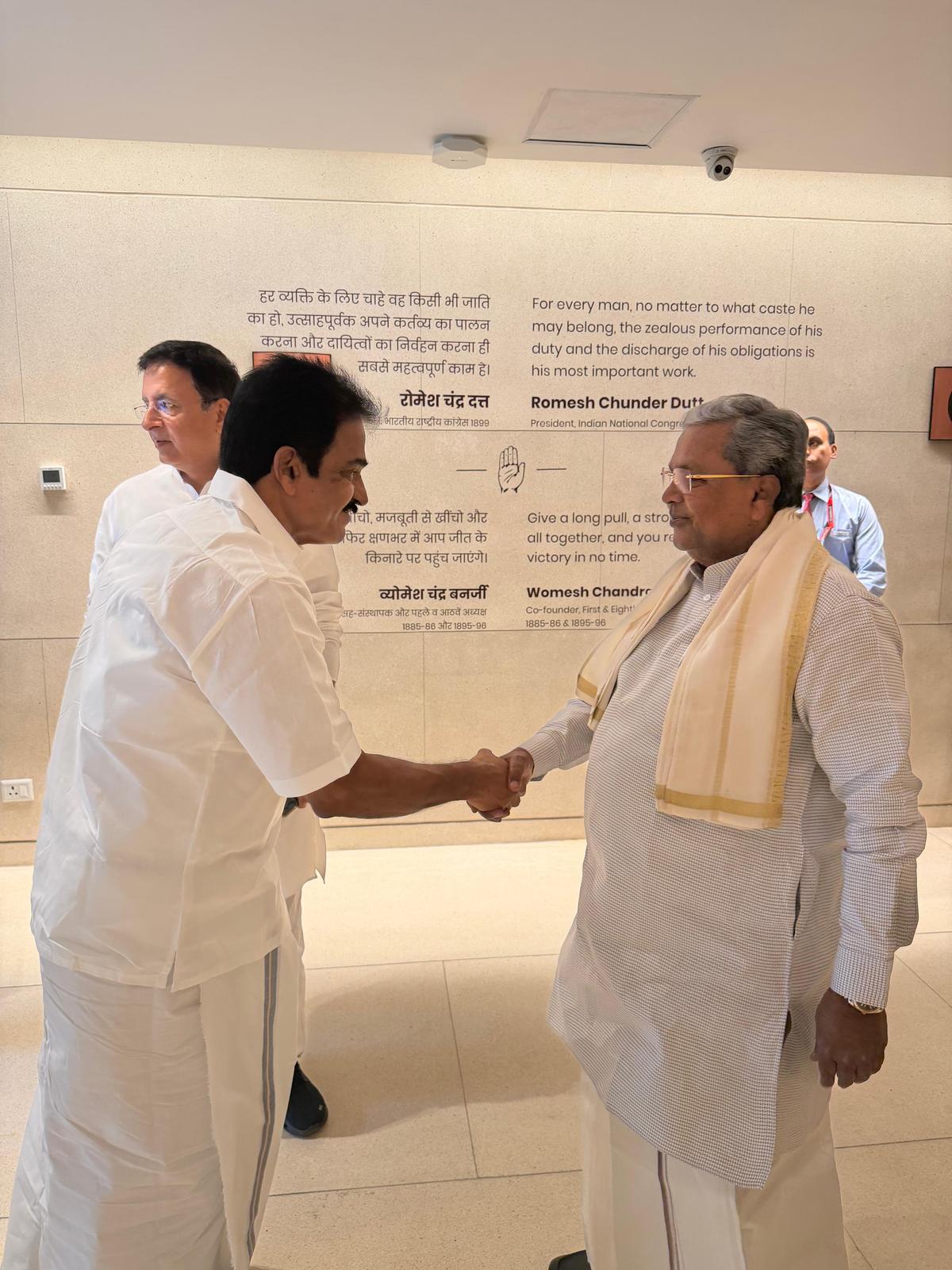 Karnataka's Chief Minister Siddaramaiah (right) welcomed at the Congress office in Delhi by the party’s general secretaries K.C. Venugopal and Randeep Singh Surjewala (background), on May 26, 2026.