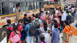 Passengers get off buses arriving from Tamil Nadu while others wait to board them after crossing the border at Attibele on Hosur Road.