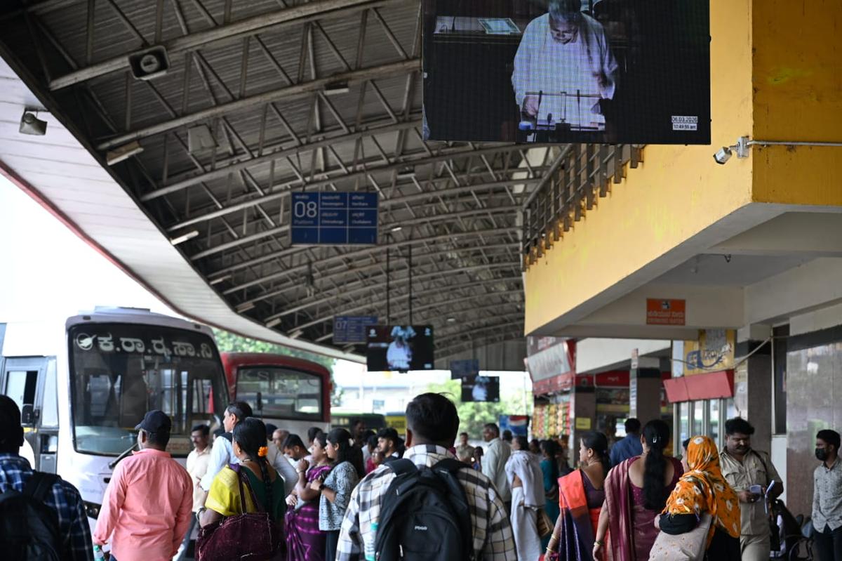 Passengers watch the live telecast of the State Budget at the KSRTC bus stand in Shivamogga on March 6, 2026. The Department of Information and Public Relations has made arrangements for live streaming of the state budget in KSRTC bus terminals across Karnataka.