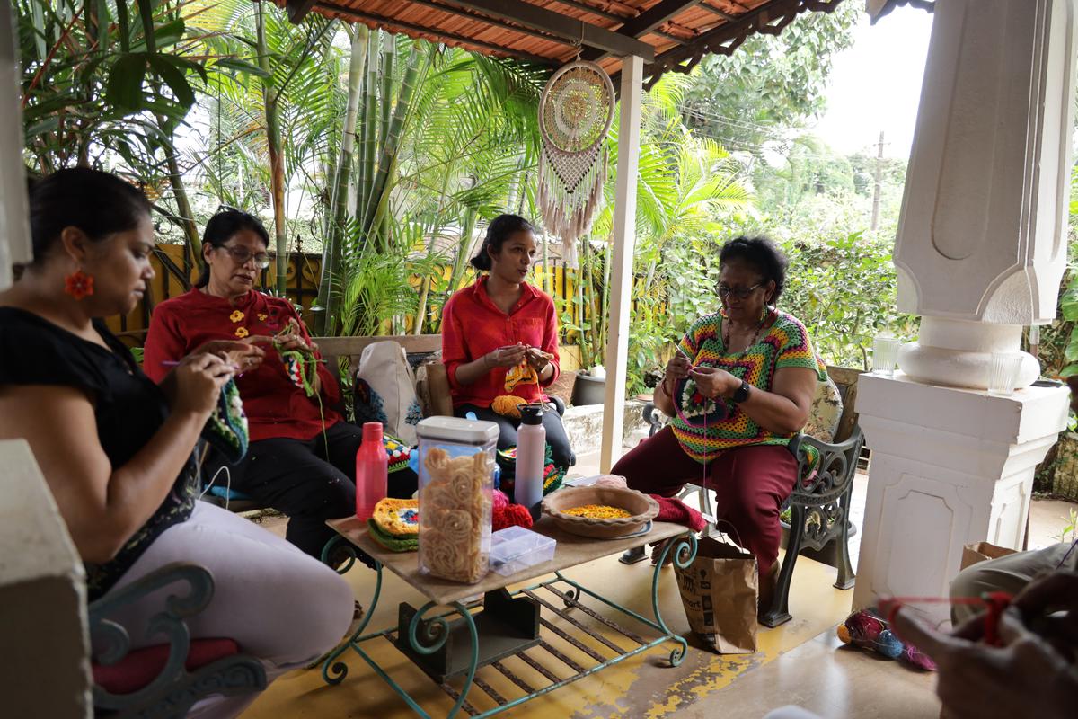 Crocheting as a collective: a few happy hands gather at a member’s house, with snacks and song, as they create granny squares for the Christmas tree