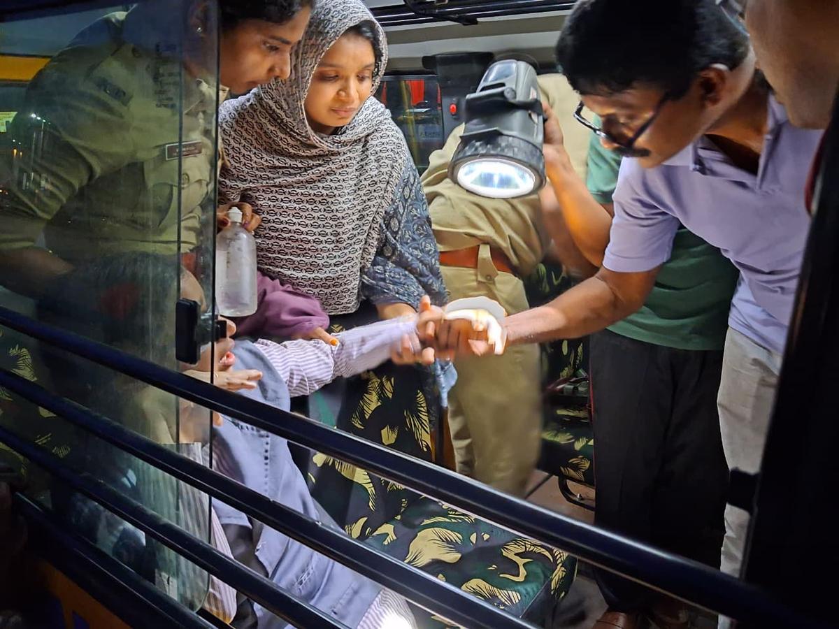 A Fire and Rescue Services officer examining the finger of Fatima Haniya. A Fire and Rescue Services officer examining the finger of Fatima Haniya.