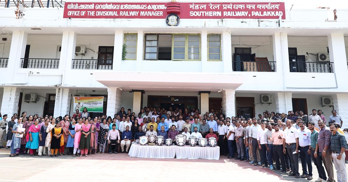 The staff at Palakkad Railway Division headquarters posing for a photo with the trophies the division won.