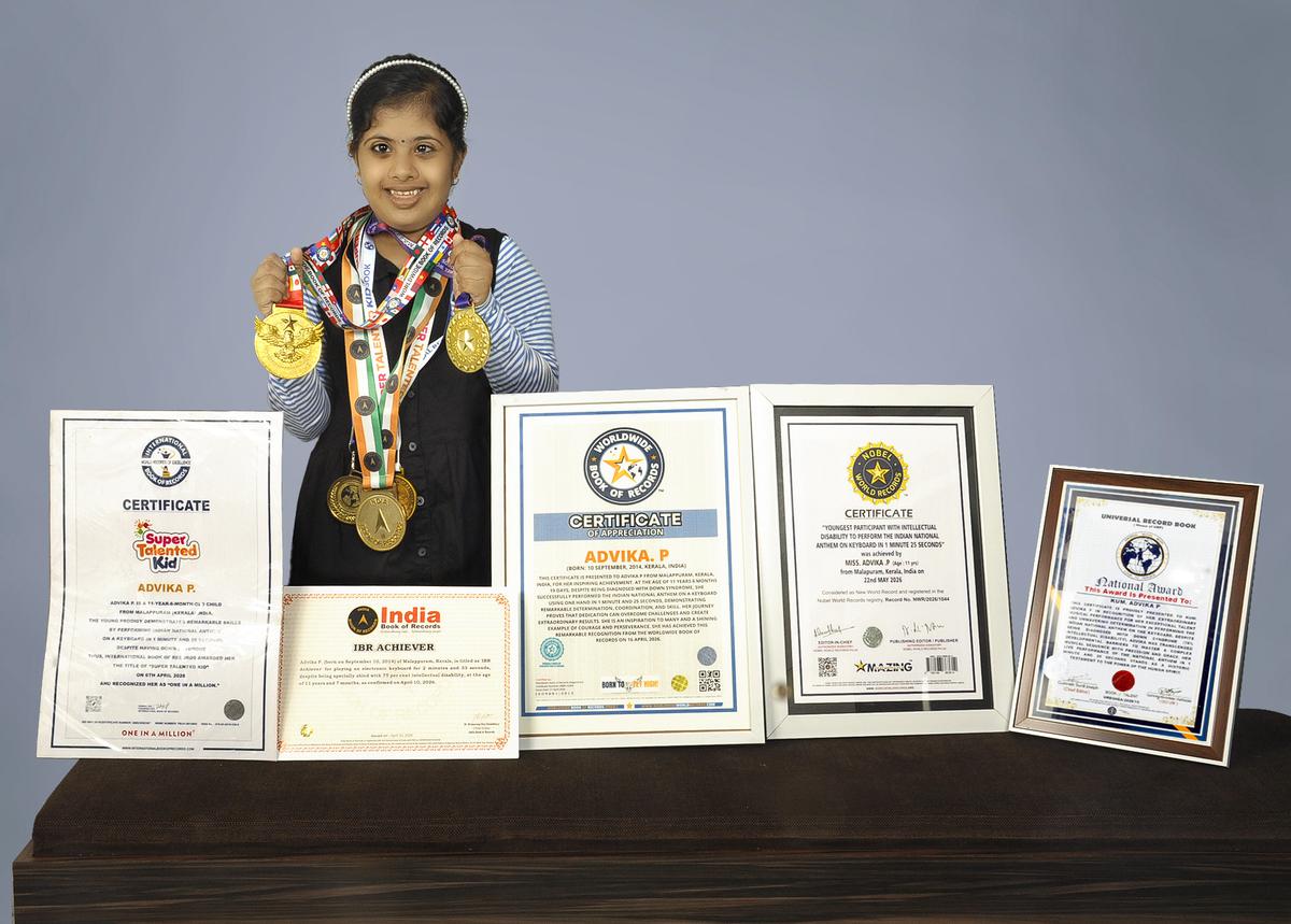 Advika posando com seus certificados e medalhas recordes.