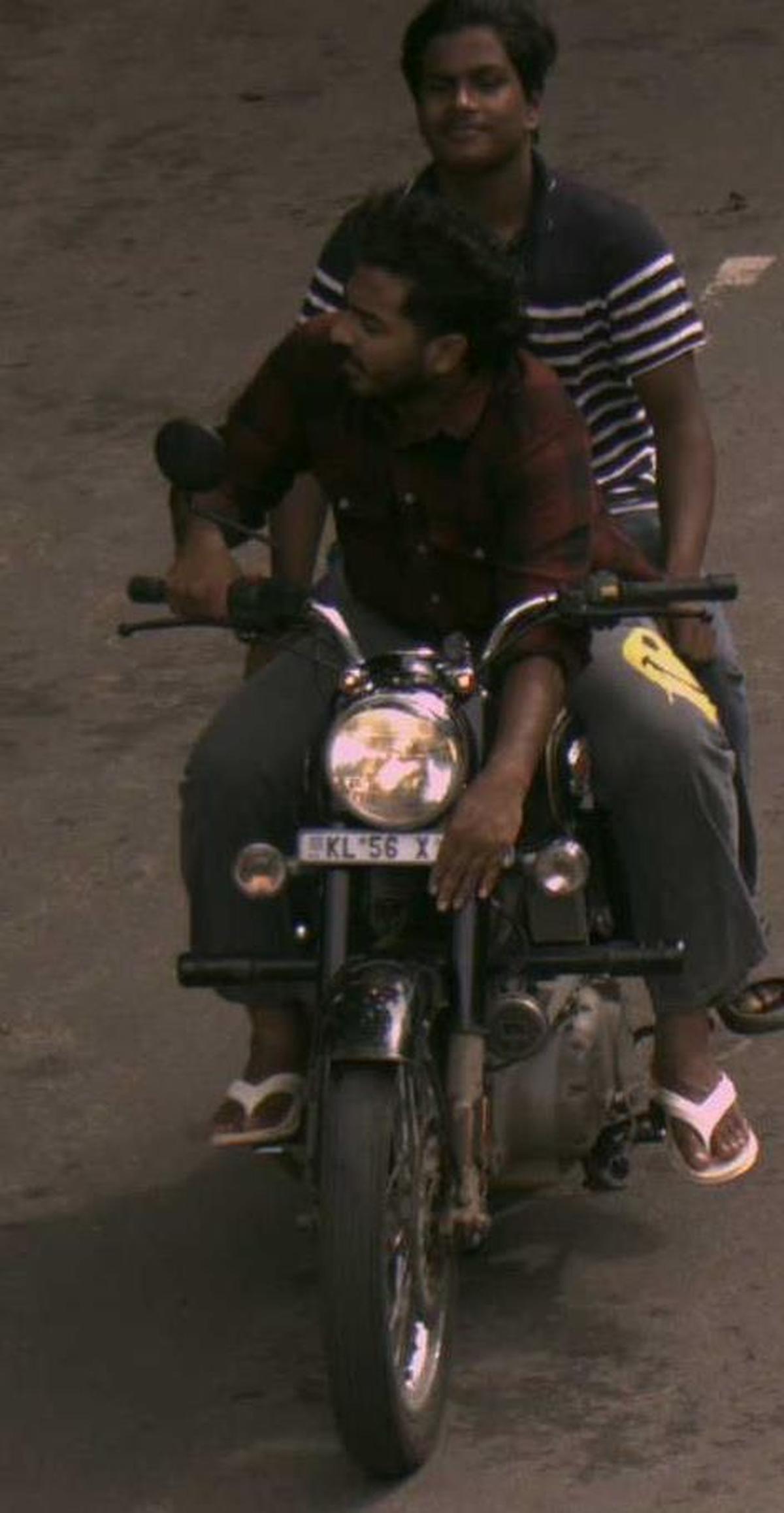 An AI camera visual accessed by the MVD and police shows a helmetless two-wheeler rider covering the number plate in front of the camera in Kozhikode district. An AI camera visual accessed by the MVD and police shows a helmetless two-wheeler rider covering the number plate in front of the camera in Kozhikode district.