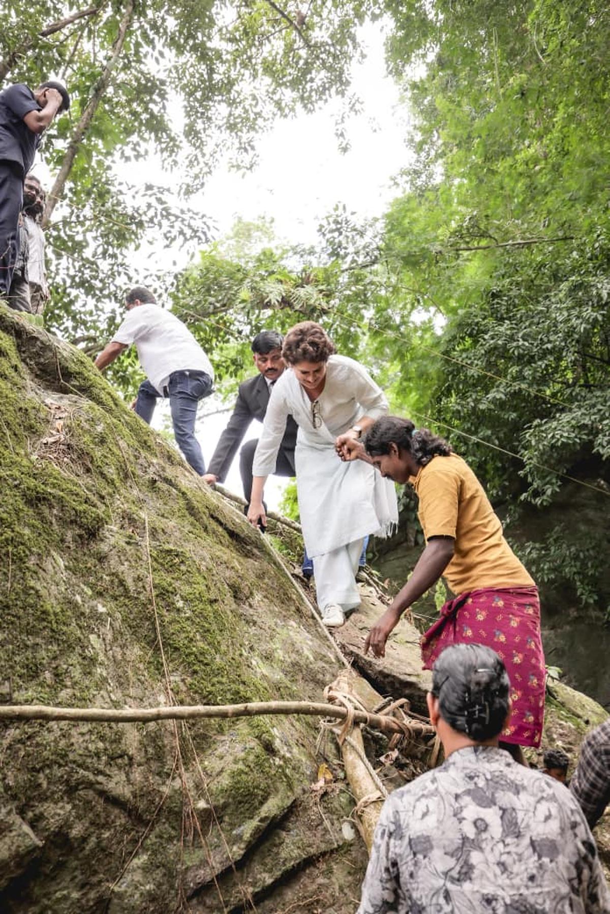 Priyanka Gandhi Vadra being helped by a tribal youth to climb down a rock. Priyanka Gandhi Vadra being helped by a tribal youth to climb down a rock.