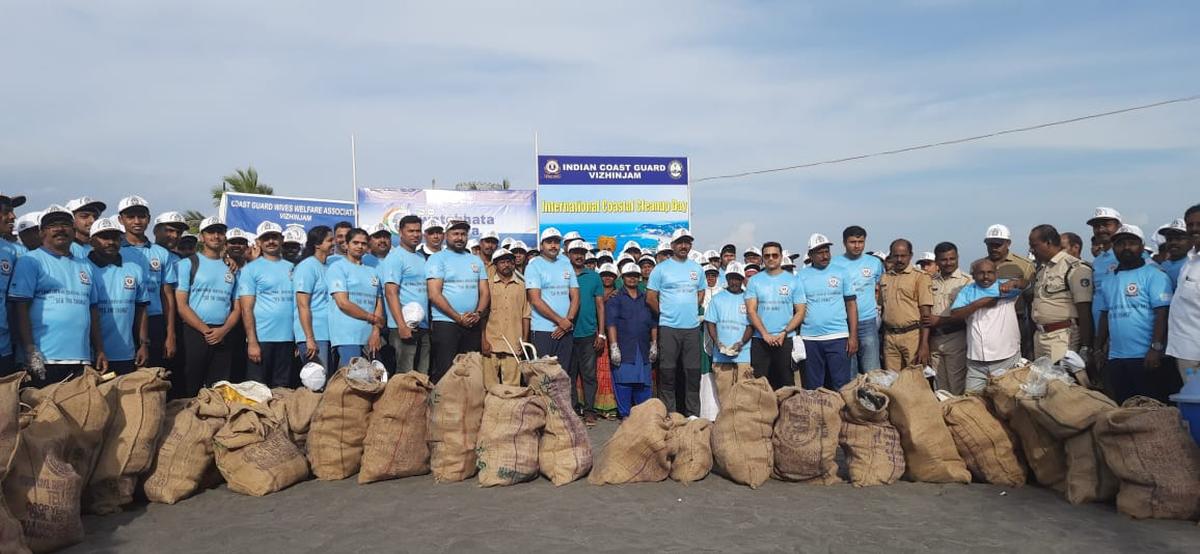 भारतीय तटरक्षक बल के स्वयंसेवक कोवलम समुद्र तट से एकत्रित कचरे की बोरियों के साथ