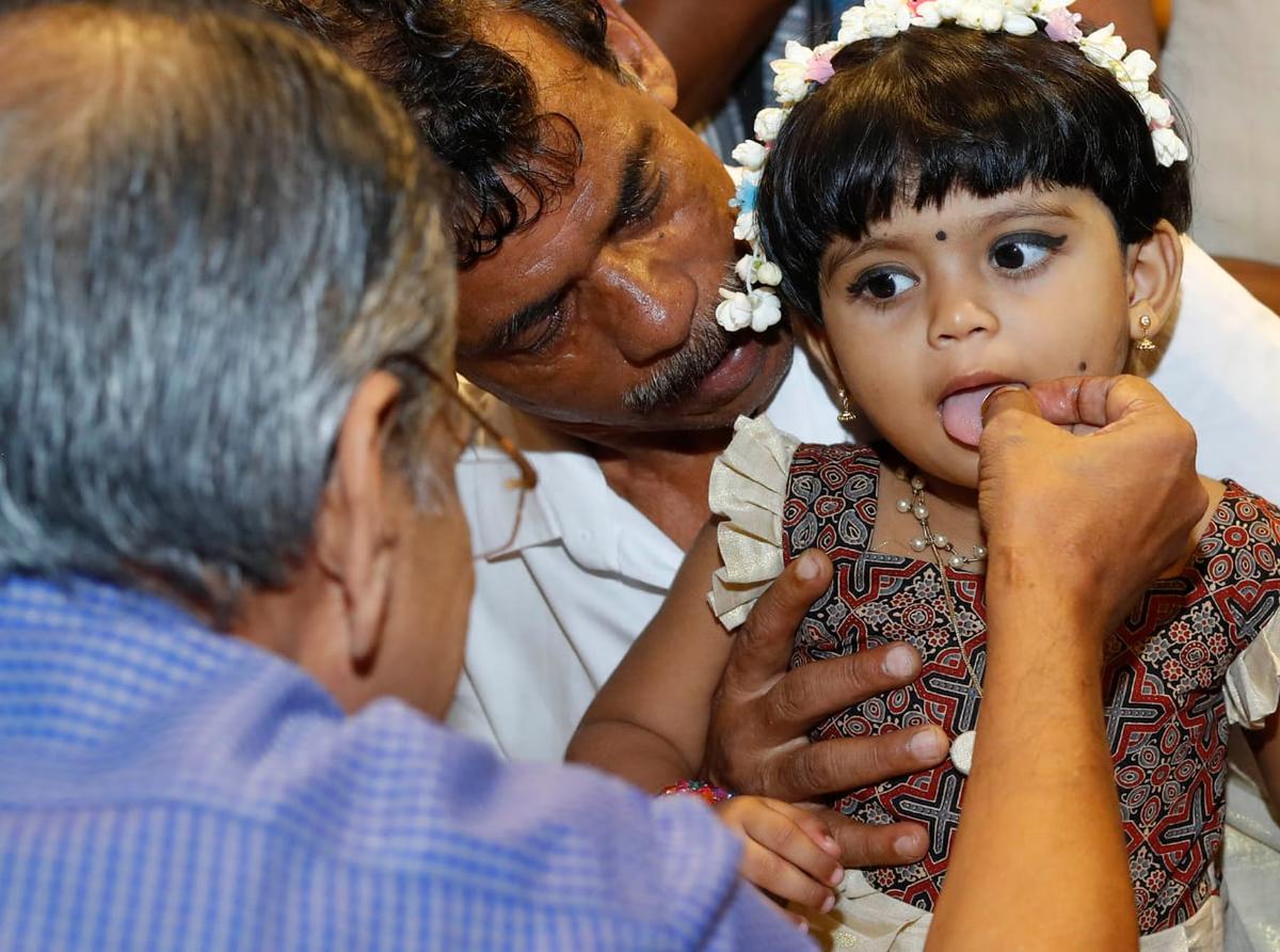 A child being initiated into the world of letters at Thunchan Paramba in Tirur, Malappuram, on Sunday. 