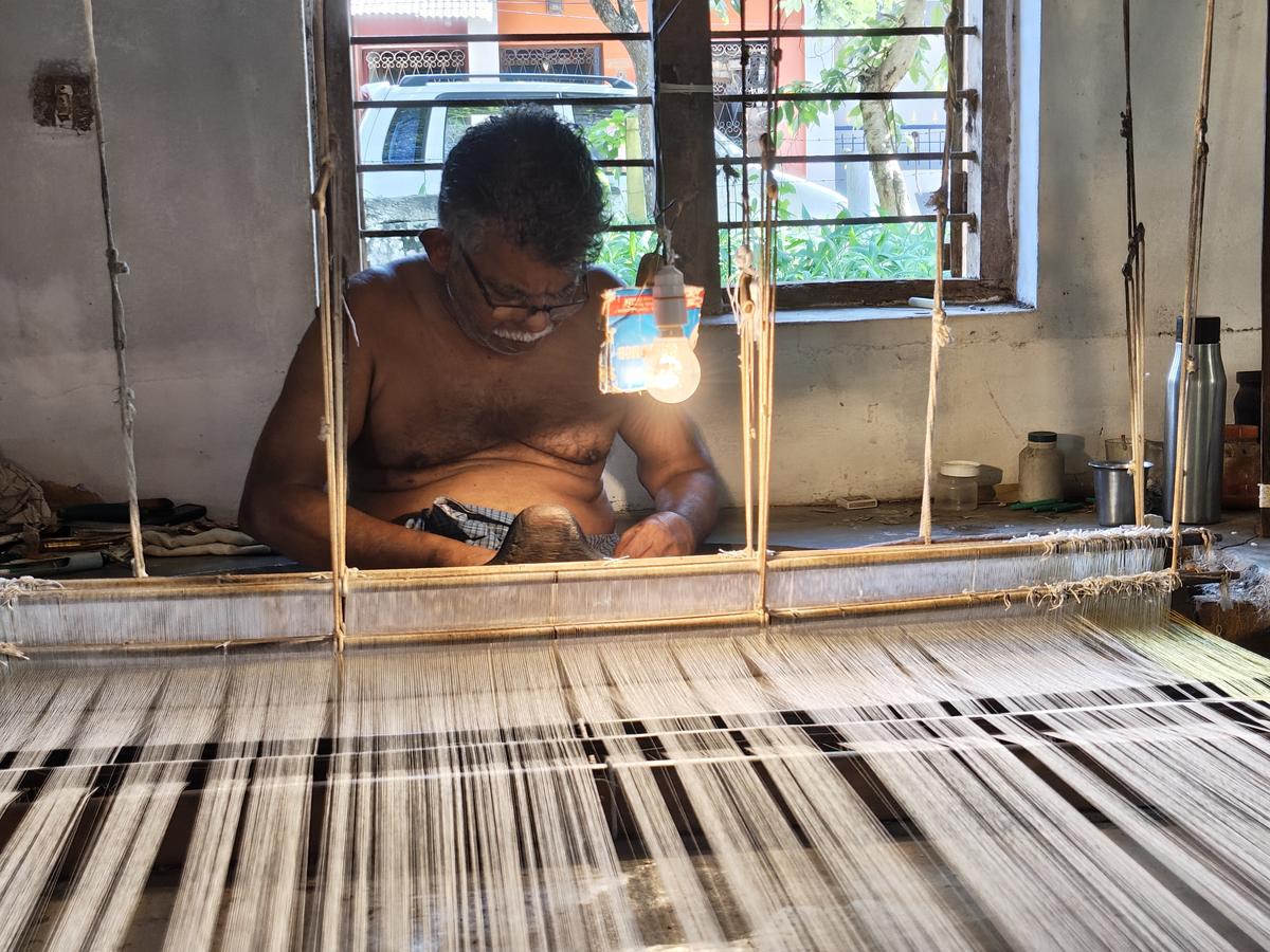 Mohanan weaving using a ‘kuzhi thari’ (pit loom) at Saliyar Street in Balaramapuram