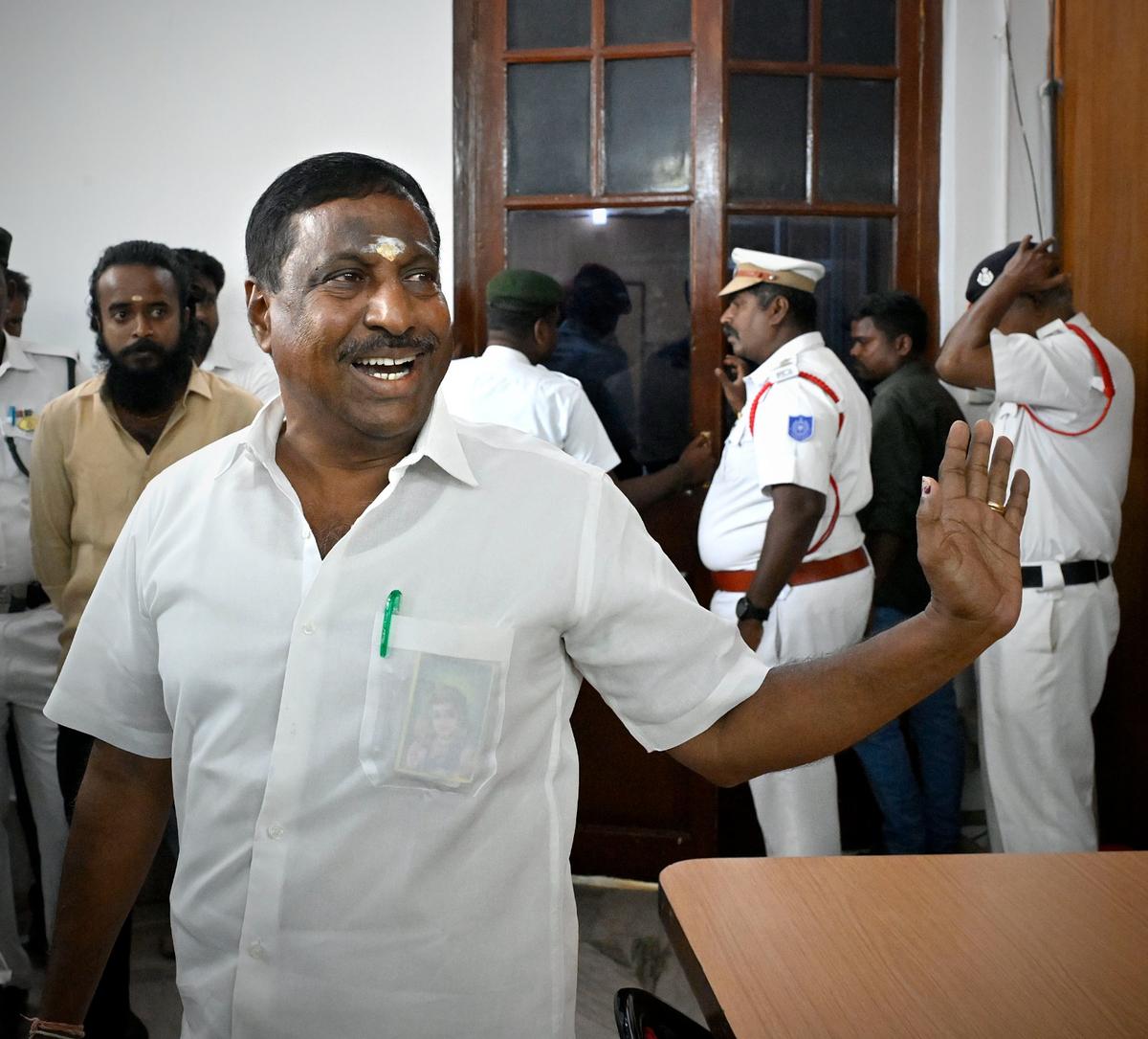 Independent legislator Nehru alias Kuppusamy being escorted out of the Assembly after the Speaker ordered his suspension