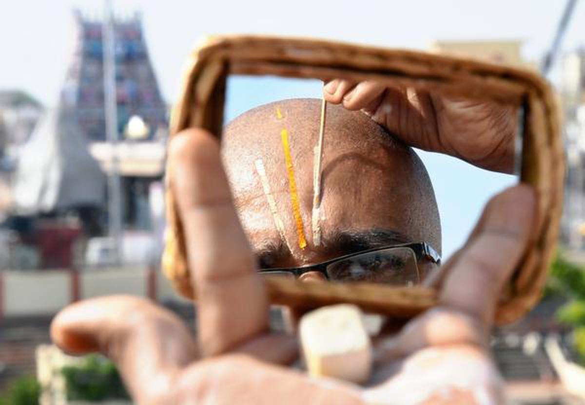 
A devotee applies ‘Thirumann’ (Holy clay). to his forehead.