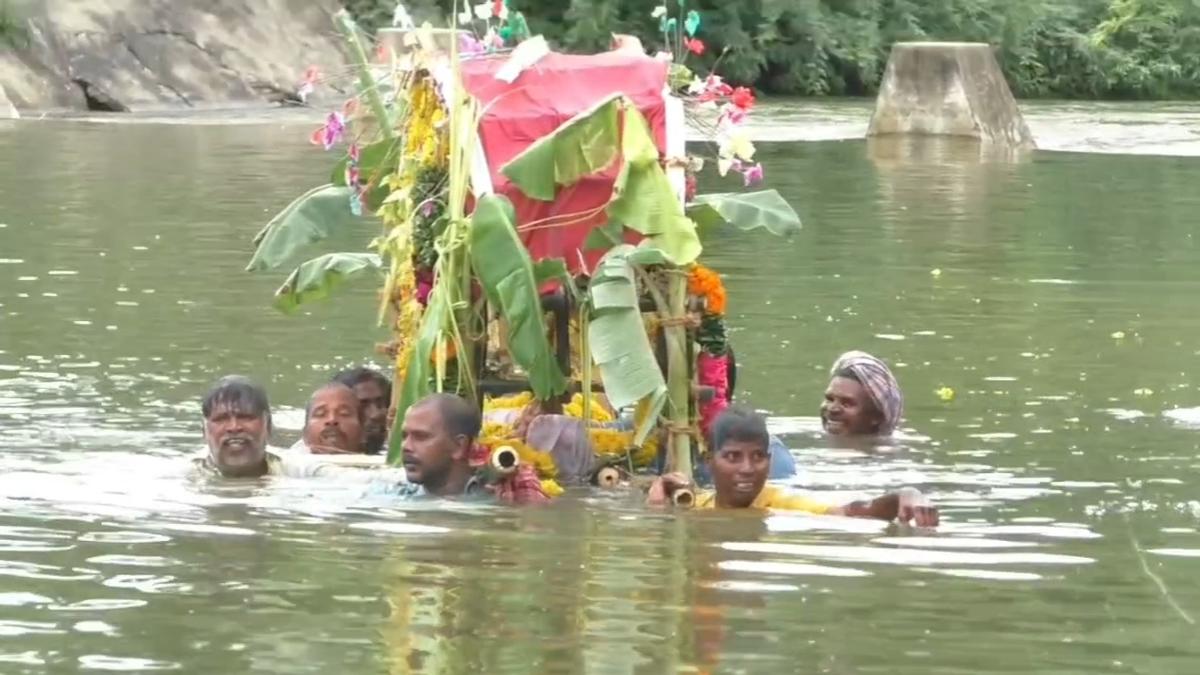 Residents wade through neck-deep canal with dead man to reach burial ground