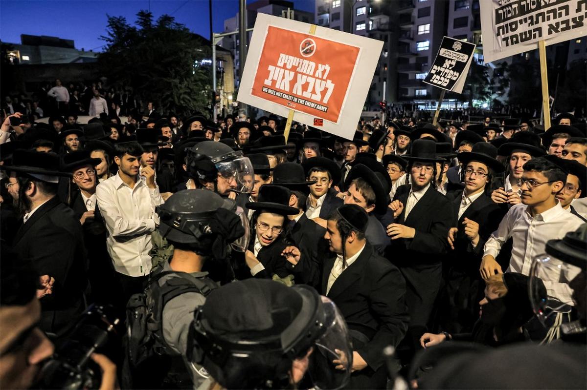 Israeli security forces confront Ultra-Orthodox Jewish demonstrators protesting a ruling by the Israeli High Court that they must be drafted into military service, in Jerusalem’s Mea Sharim district on June 30, 2024. 