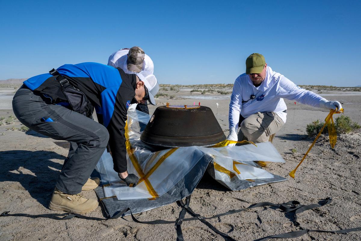 NASA scientists prepare a return capsule containing a sample collected from the asteroid Bennu in October 2020 by the OSIRIS-REx spacecraft shortly after it touched down in a desert in Utah, U.S., September 24, 2023.