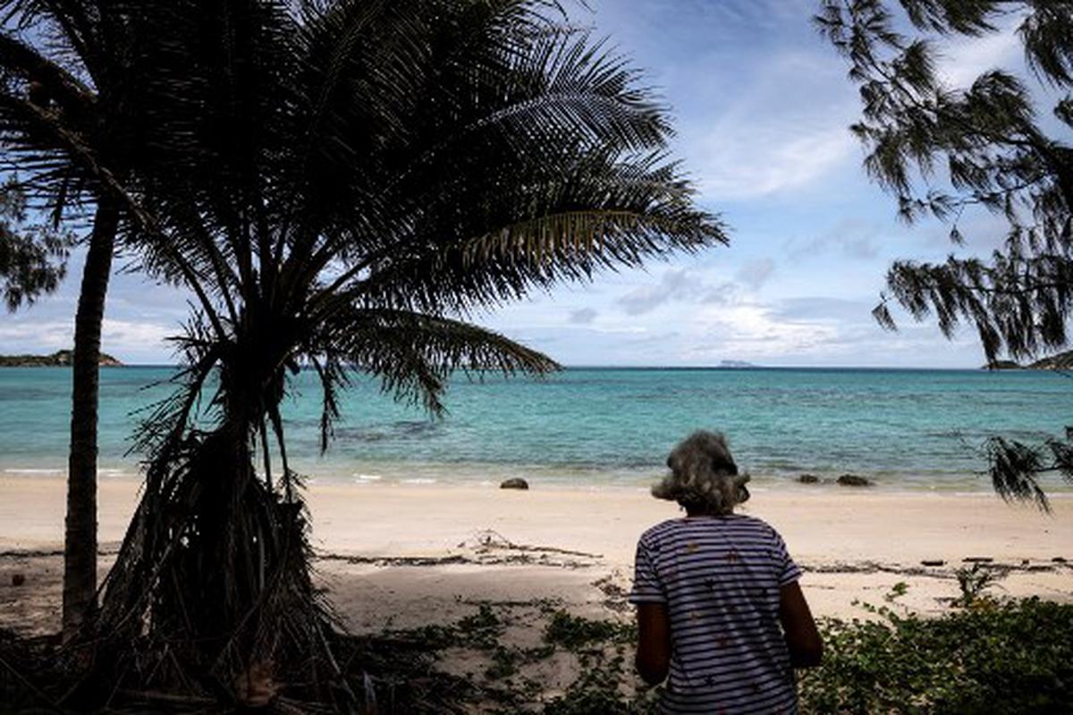 This photo taken on April 4, 2024, shows a woman standing on a beach on Lizard Island on the Great Barrier Reef, located 270 kilometres (167 miles) north of the city of Cairns. Australia’s famed Great Barrier Reef is teetering on the brink, suffering one of the most severe coral bleaching events on record -- the fifth in eight years -- and leaving scientists unsure about its survival.