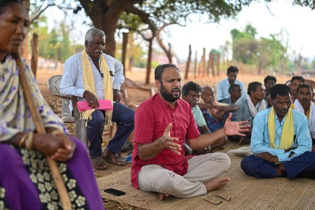 This photograph taken on April 13, 2024 shows Alok Shukla (C), an activist, speaking with the tribals during a meeting at the Morga village of Korba district in India’s state of Chhattisgarh. Shukla has led a decade-long grassroots campaign against some of India’s conglomerates -- including one operated by Adani Group, helmed by Asia’s second-richest man -- seeking to tap one of the country’s richest subterranean stores of fossil fuels. 