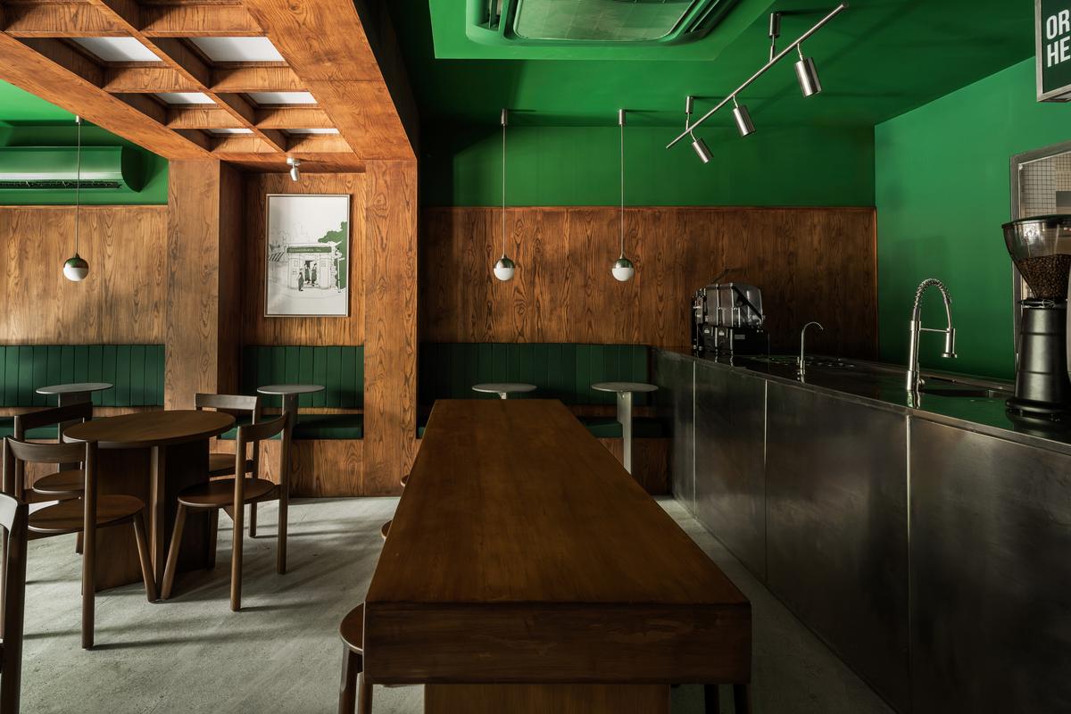 A deep forest green hue dramatically washes over the walls and booths at Beyondburg inc.