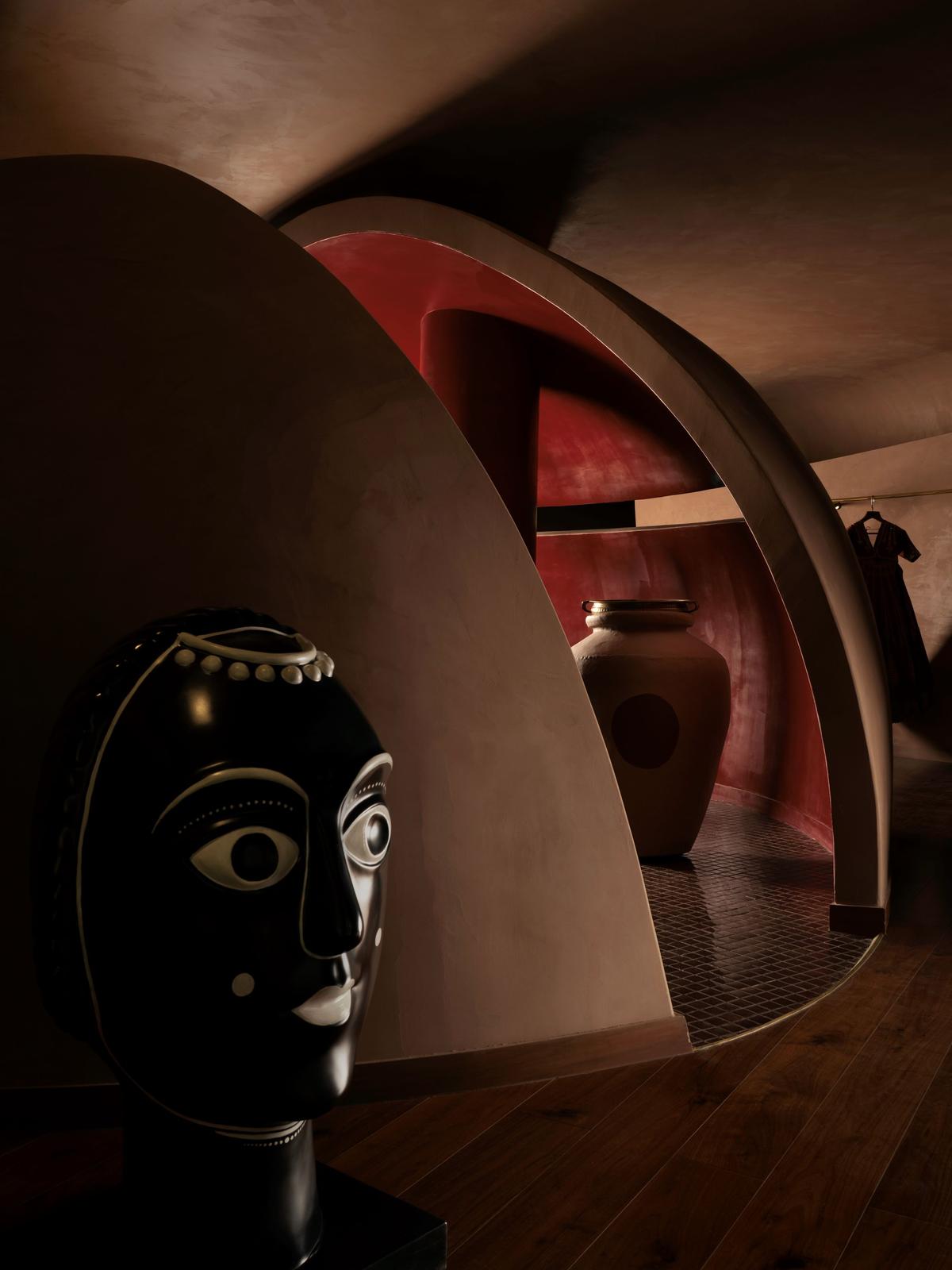 The store is a cave-like structure with terracotta-tinted walls with splashes of red, maroon and burgundy. 