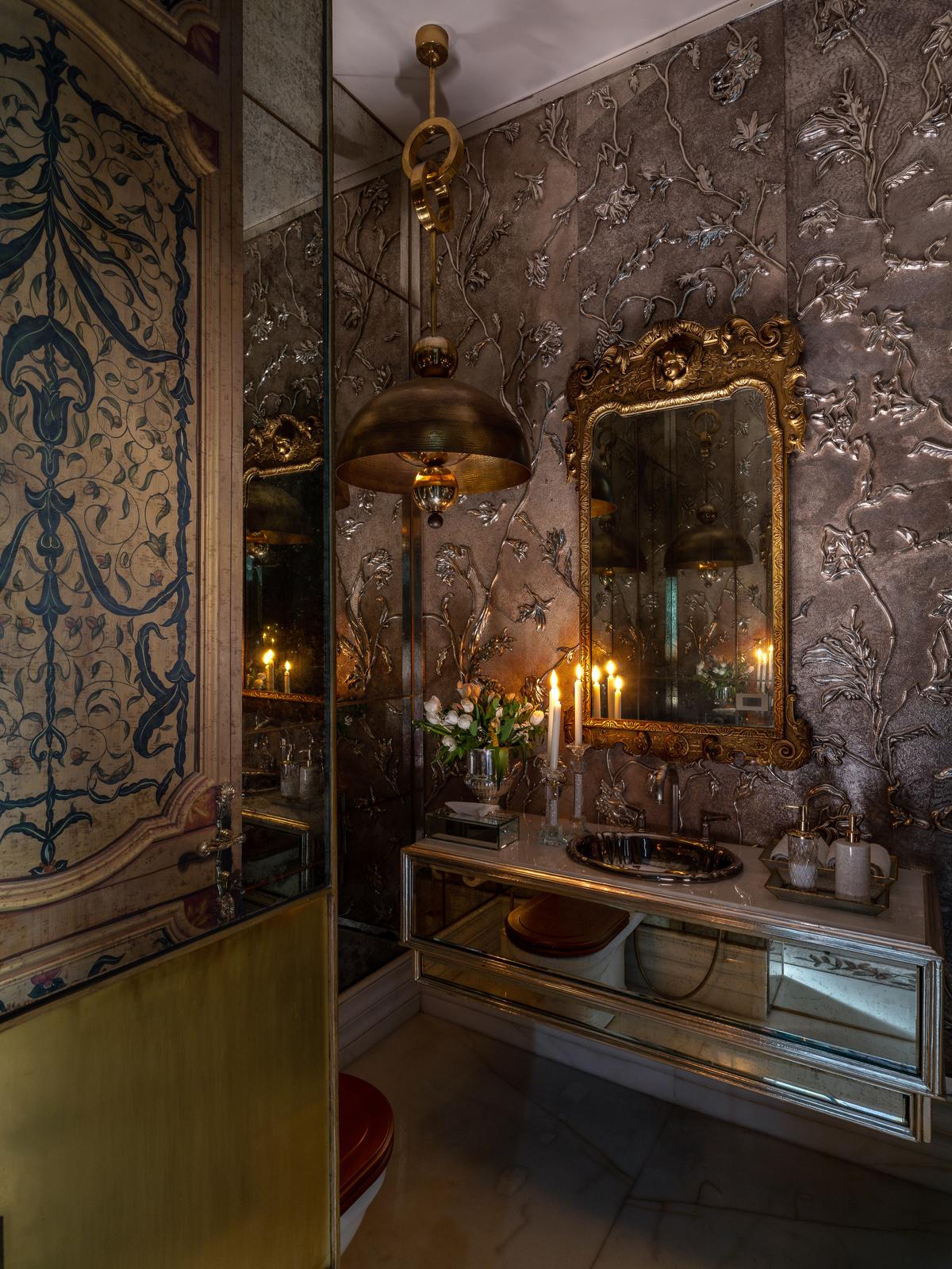 Intricate floral wall textures and gilded accents bring a sense of timeless elegance to this powder room. Intricate floral wall textures and gilded accents bring a sense of timeless elegance to this powder room.