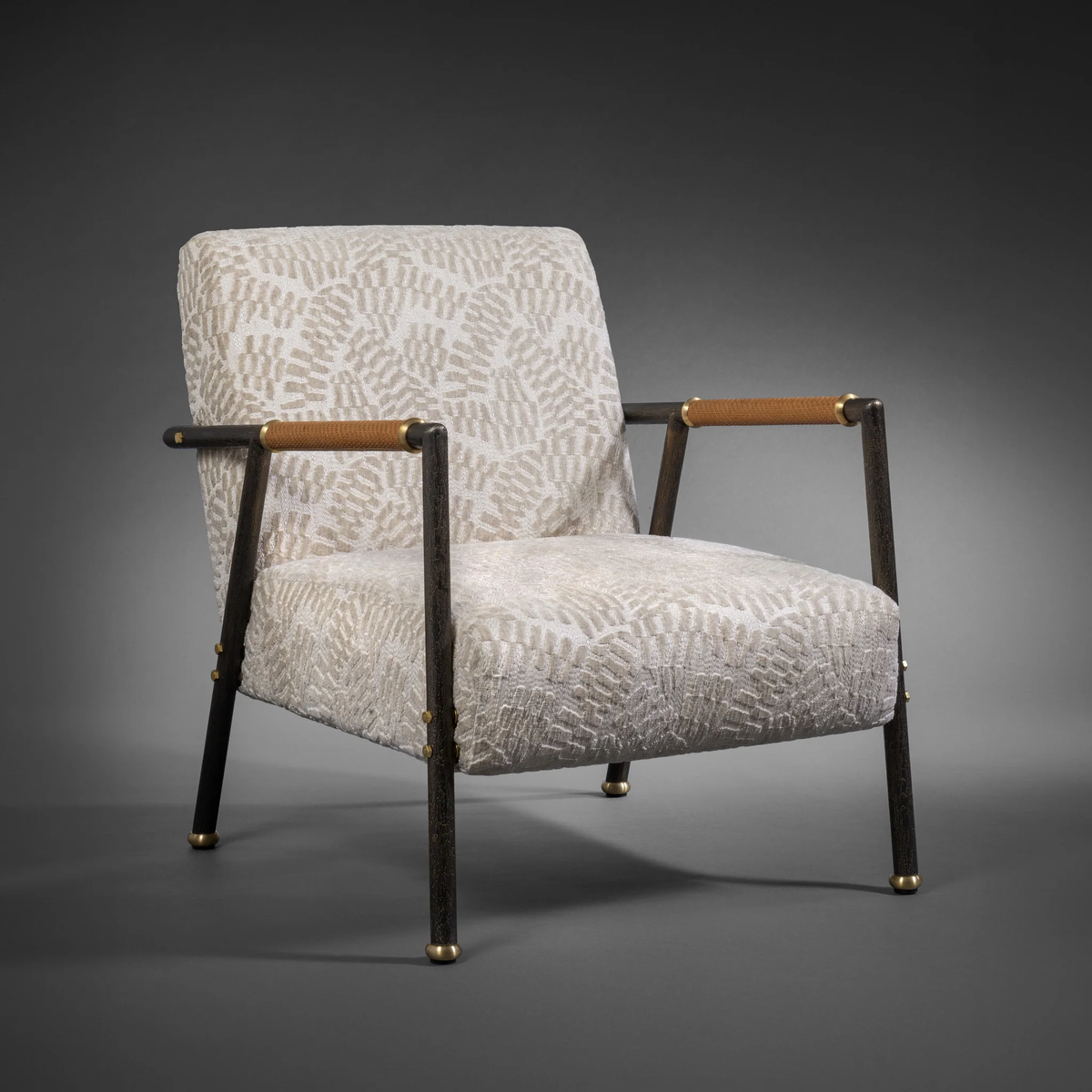 Lodge armchair is crafted from textured and patinated brass structure with solid cork armrests wrapped in woven leather fabric.