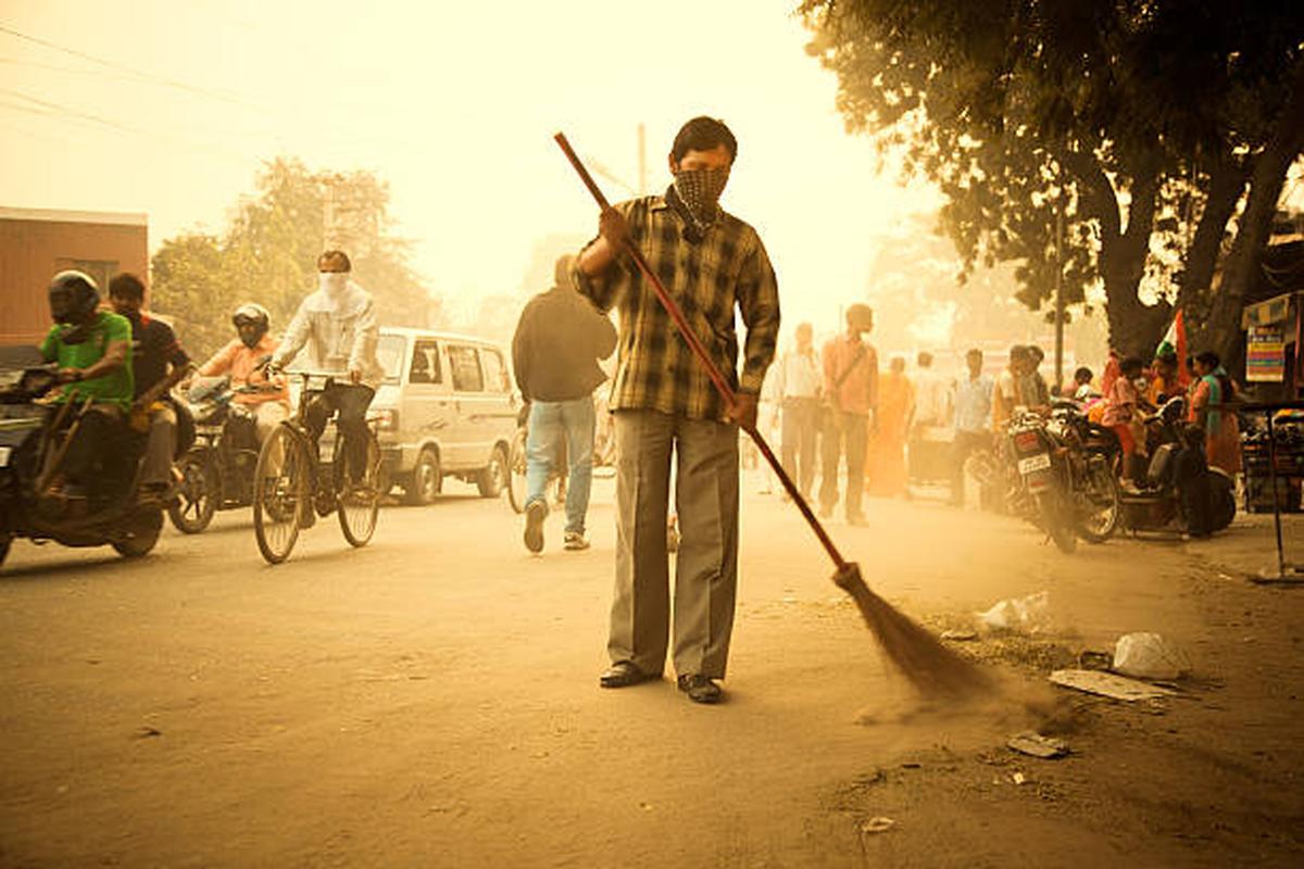 Crowded and dirty street; a worker cleaning the road in Delhi. Crowded and dirty street; a worker cleaning the road in Delhi.