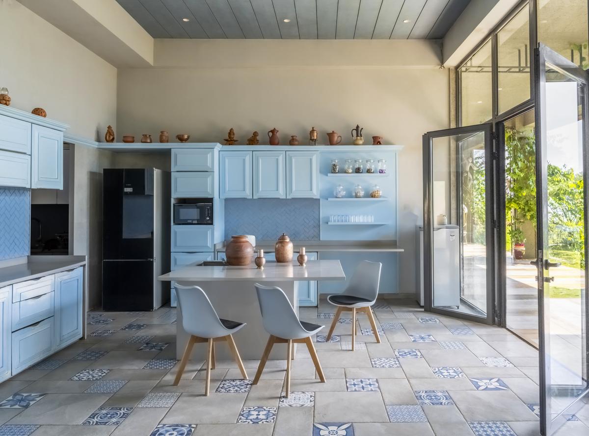Grey tiles with blue patterned insets bring a touch of Moroccan charm to the kitchen, balancing utility with visual rhythm.