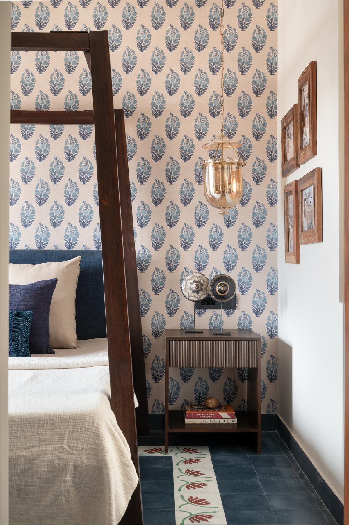 Bedroom featuring a four-poster bed set against a striking Sabyasachi wallpaper, with handcrafted floral inlay flooring that adds an elegant layer of detail to the space.