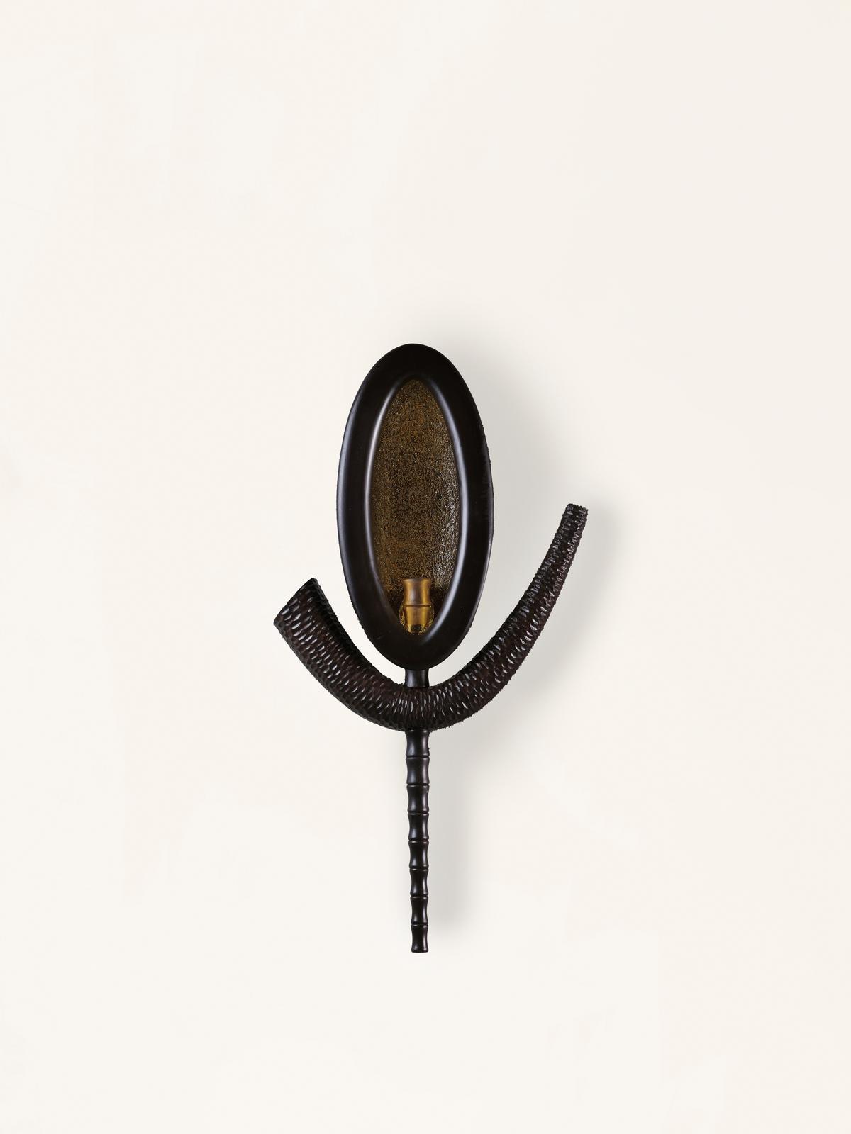 The sconce features hand-carved reclaimed teak with tactile richness and rustic charm. The sconce features hand-carved reclaimed teak with tactile richness and rustic charm.