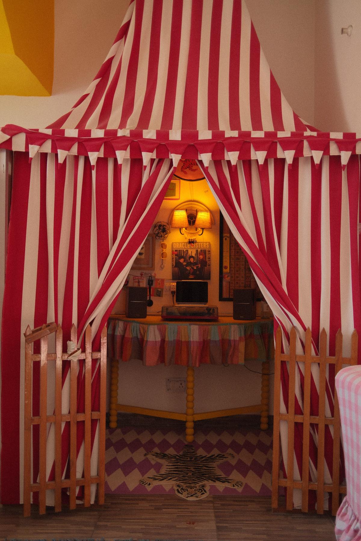 A whimsical, striped vinyl tent blurs the typical boundary between inside and outside at Malhotra’s Dehradun rental. 