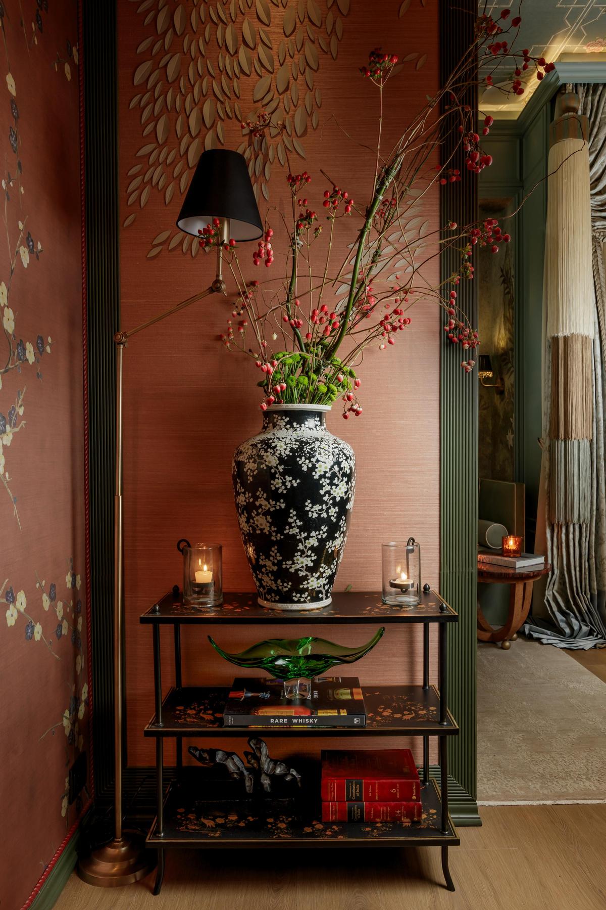 Fragrance finds form in texture and tone, crimson berries, candlelight, and silk walls conjure a scent narrative of warmth and spice, enveloping the corner in quiet opulence. 