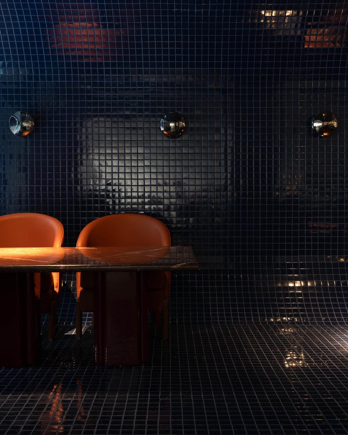 Curved seating with vibrant orange color, perfectly blending in the space giving a more illuminating look.