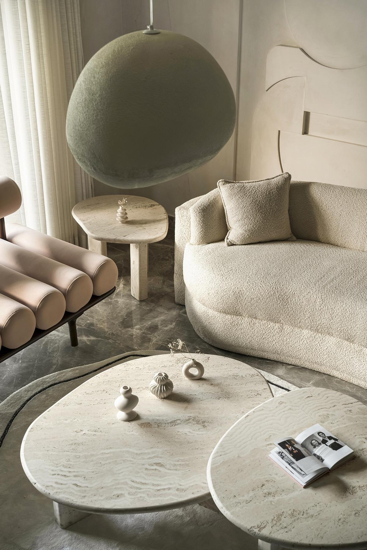 A warm minimalistic space with unusual curved lighting and a textured sofa.