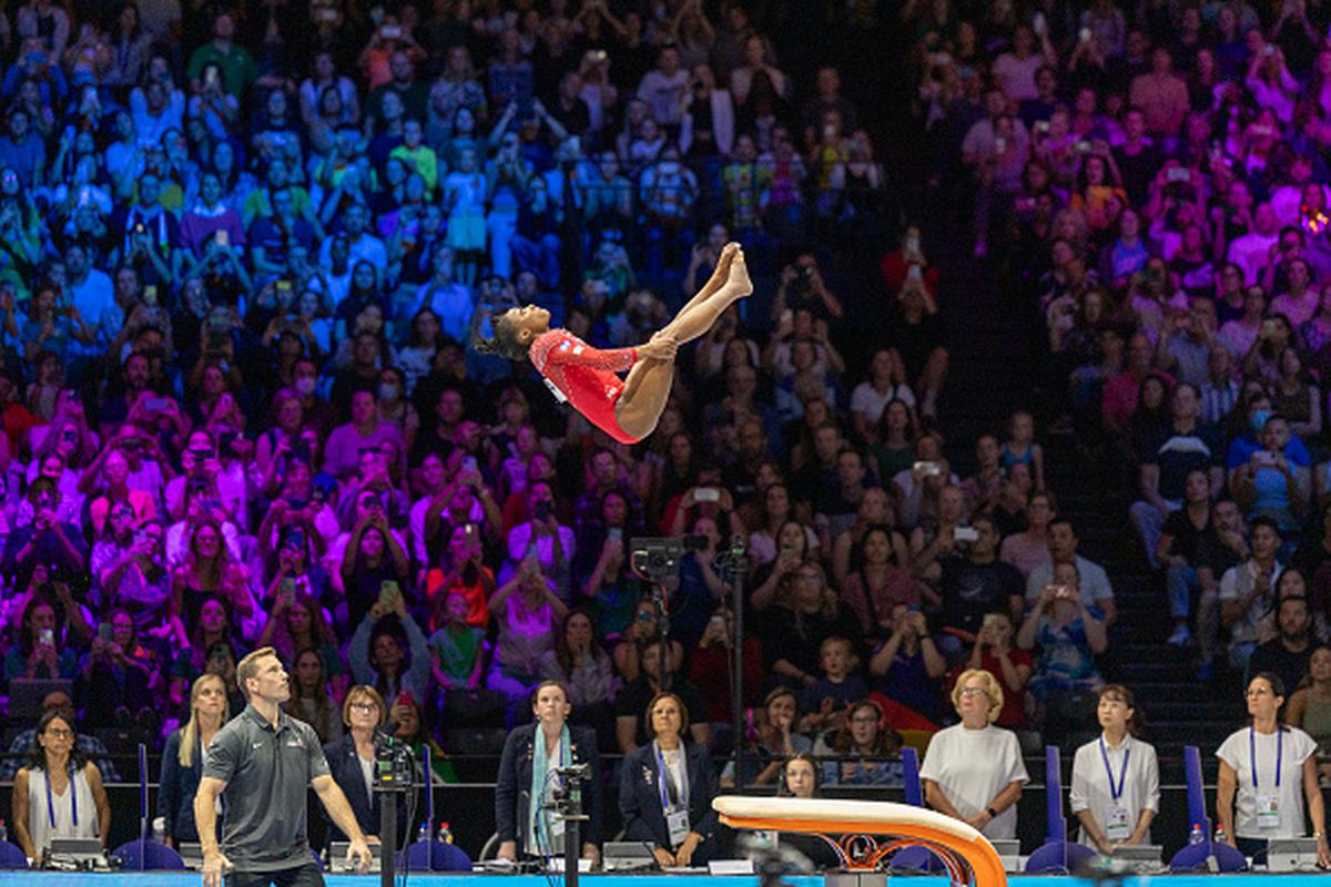 Fearless pioneer: Biles performs the Yurchenko double pike, now renamed the Biles II, watched by coach Laurent Landi and the judges. She became the first woman to land the daunting vault in international competition at the Worlds during qualifying.