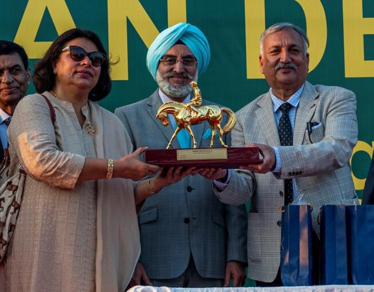 Miss Ameeta Mehra receiving the Indian Derby trophy from S.R. Sanas, chairman of RWITC, as P.S. Bedi, chairman of Delhi Race Club, looks on. 