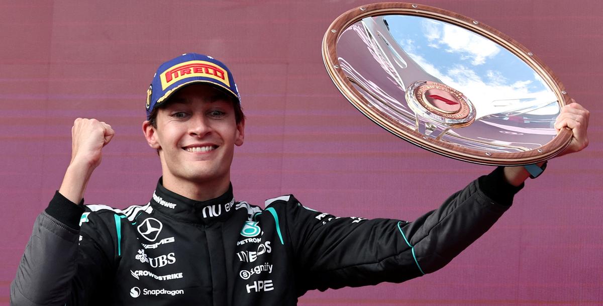 ऑस्ट्रेलियन ग्रां प्री जीतने के बाद जॉर्ज रसेल पोडियम पर ट्रॉफी के साथ जश्न मनाते हुए।