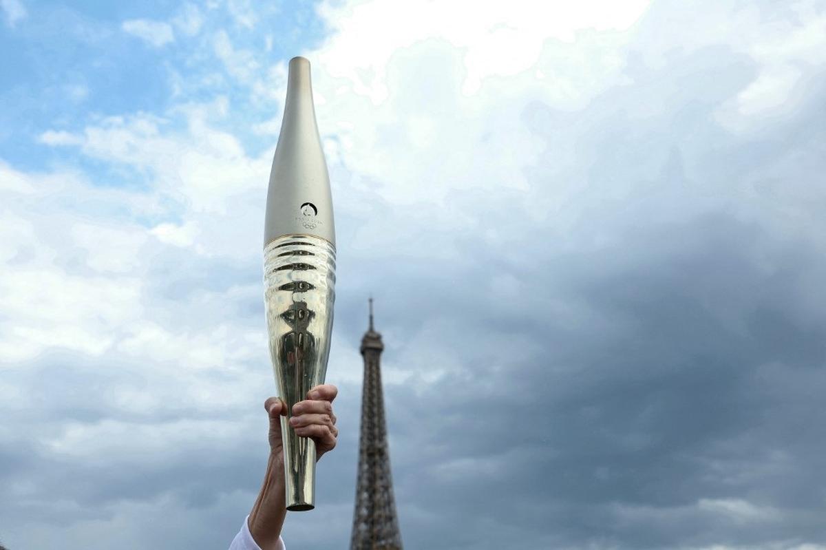 This photograph shows the Olympic torch with the tip of the Eiffel Tower in the background during the Olympic torch relay in Paris on July 15, 2024, ahead of the Paris 2024 Olympic and Paralympic Games. (Photo by ALAIN JOCARD / AFP)