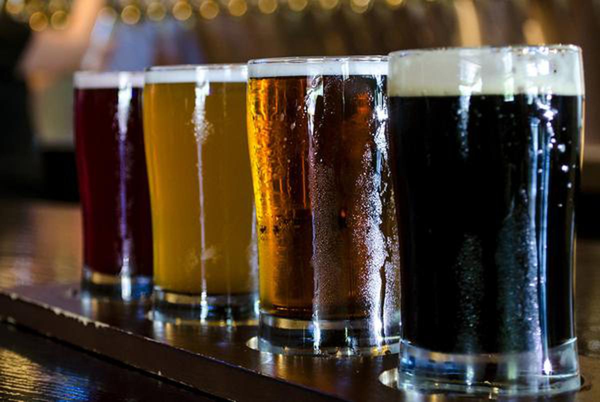 A flight of 4 craft beers lined up on the bar.