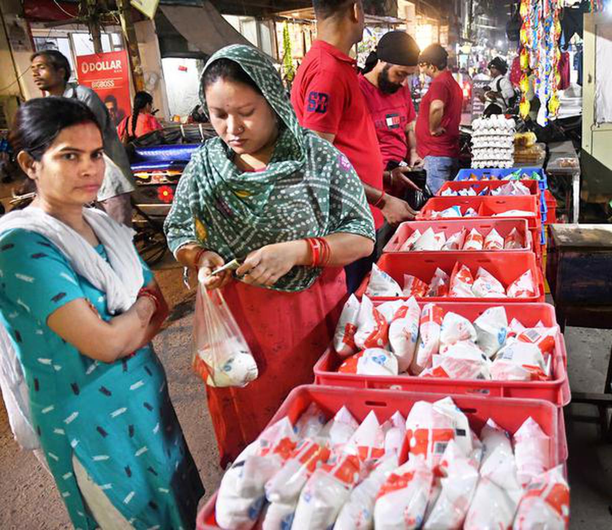 Customers purchase milk packets at a store in Uttar Pradesh’s capital Lucknow.