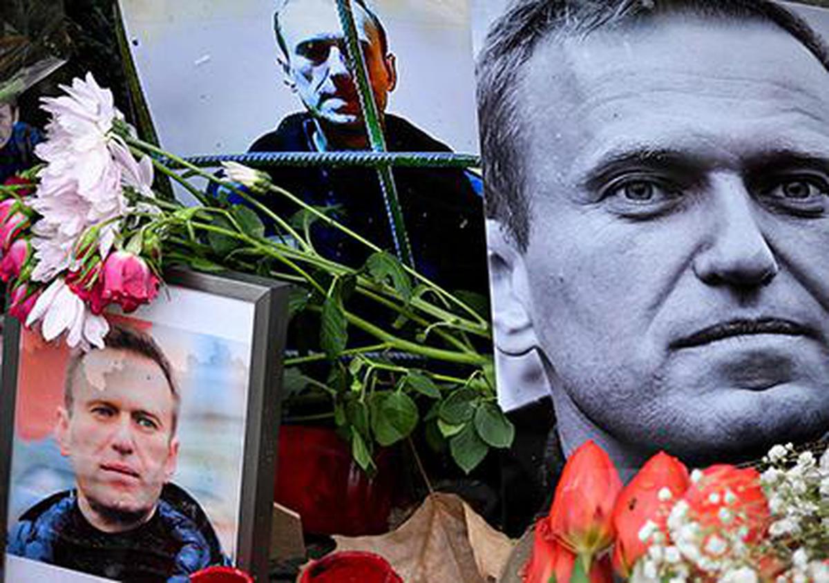 Flowers are seen placed around portraits of late Russian opposition leader Alexei Navalny, who died in a Russian Arctic prison, at a makeshift memorial in front of the former Russian consulate in Frankfurt am Main, western Germany, on February 23, 2024. 